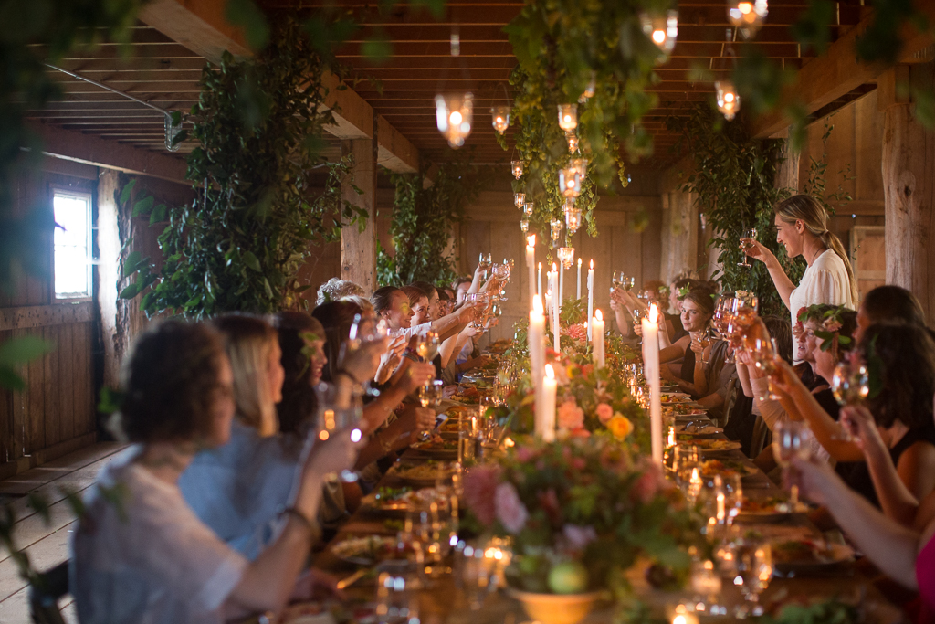 A group of students and Erin Benzakein cheers at a beautiful candle-lit dinner at the close of an on-farm Floret workshop
