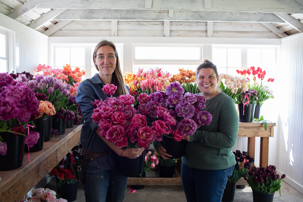 Erin Benzakein and Jill Jorgensen holding buckets of specialty tulips in the Floret studio